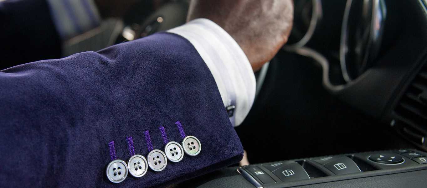 Men's purple tailored suit showing buttons and cuff detail in car